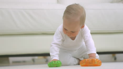 Baby-playing-with-toys-on-the-floor