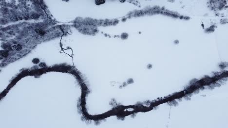 vista aérea sobre un río de montaña cubierto de nieve en invierno