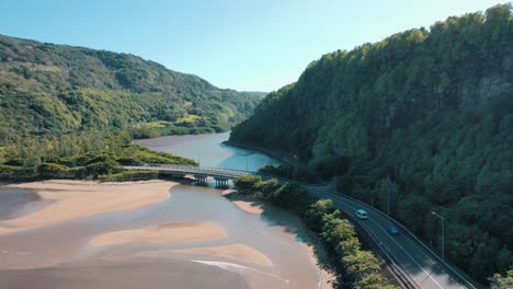 Aerial-shot-of-amazing-Maconde-beach-on-beautiful-sunny-day-as-traffic-drives-by