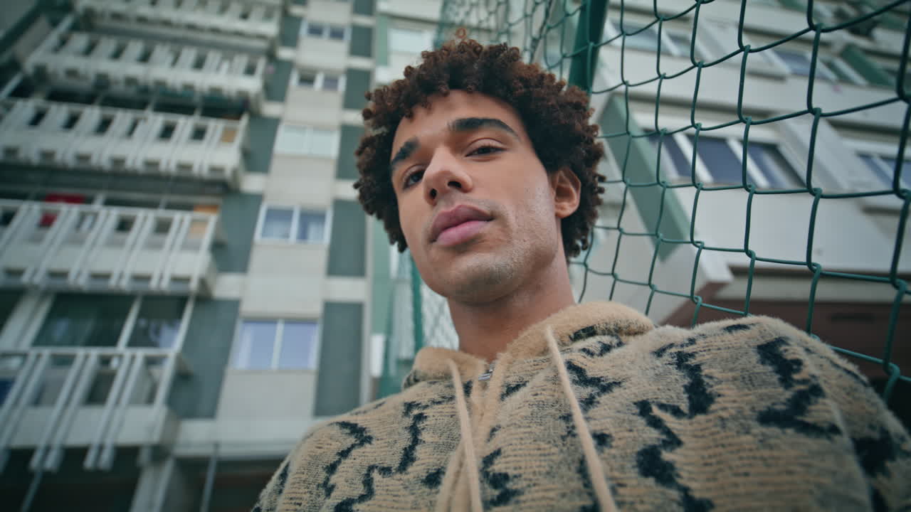 estudiante casual relajándose en la calle con un suéter texturizado que exuda calma en primer plano.