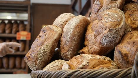 a bakery worker reaching into a basket of freshly baked bread