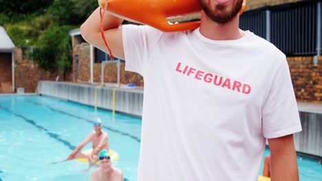 swim coach standing inflatable floater near poolside