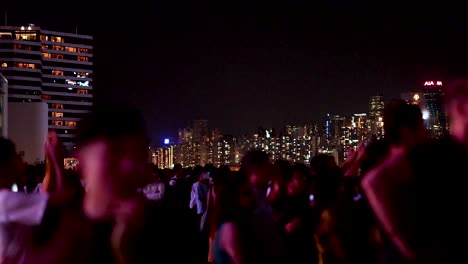 people gather under city lights at night