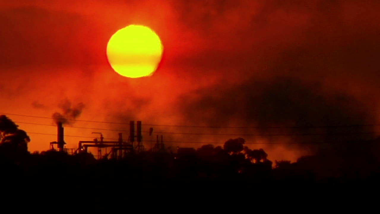 el humo se mueve por el cielo en una zona industrial durante la hora dorada