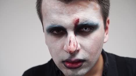 detail closeup of man with face paint and contact lens in eye, slow motion