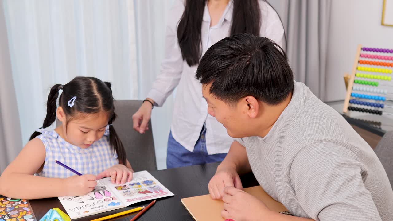 A family engages in drawing and painting at a table, fostering creativity and togetherness in a bright, colorful setting