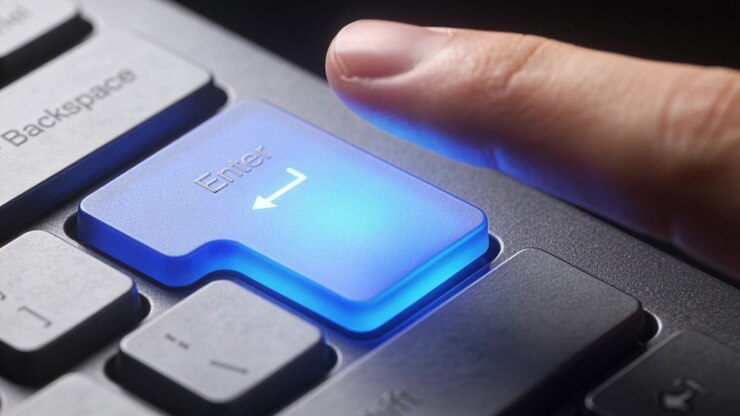 Pressing fingertip, moving hand and releasing illuminated Enter key on backlit keyboard, submitting