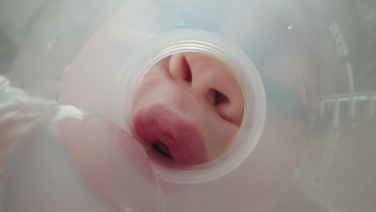 금발 어린 소녀 는 플라스틱 병 목 에서 물 을 마신다