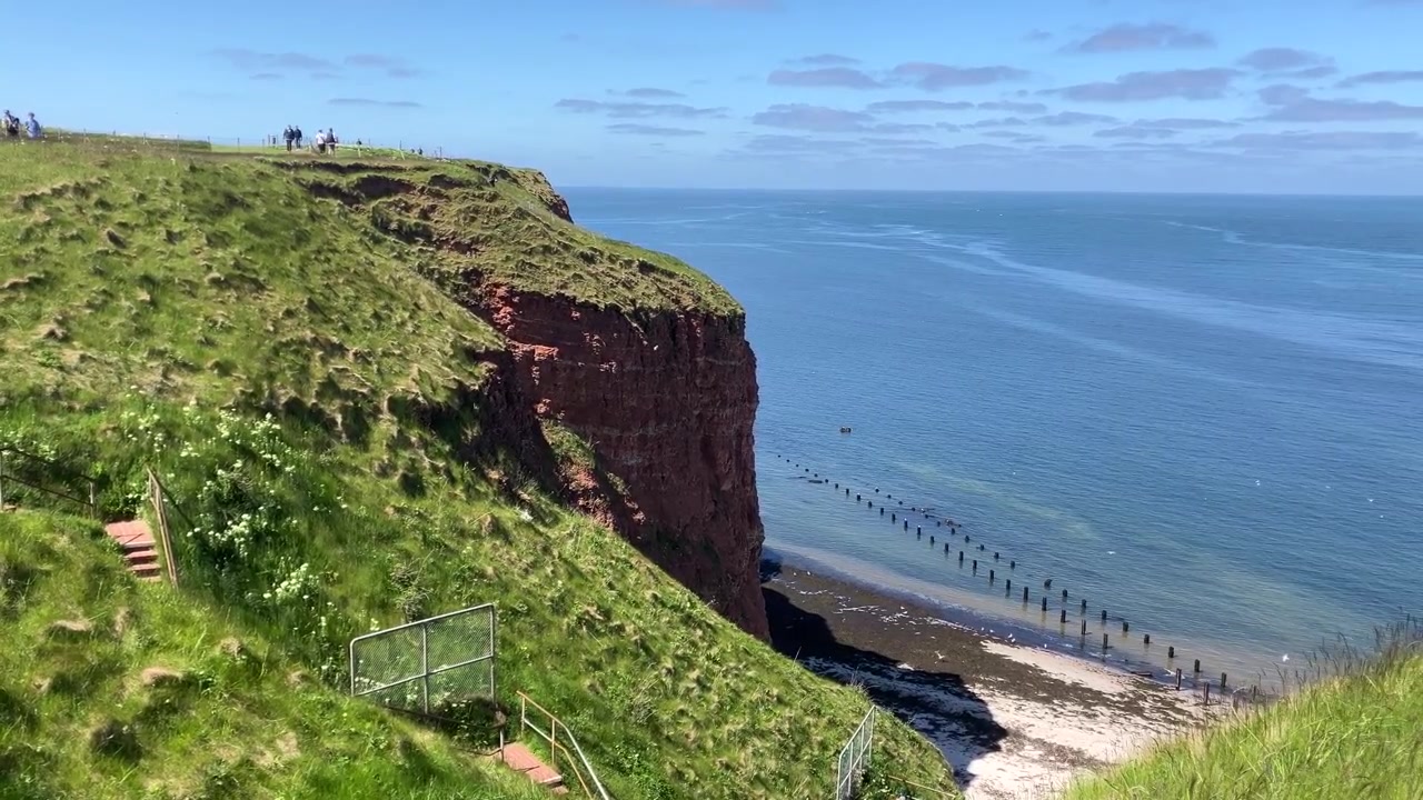Statisk utsyn som viser trappeformede klipper og strandlinjen nedenfor.