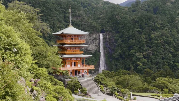 Seigantoji Temple with Nachi Falls in the background, daytime with lush green forest, static shot