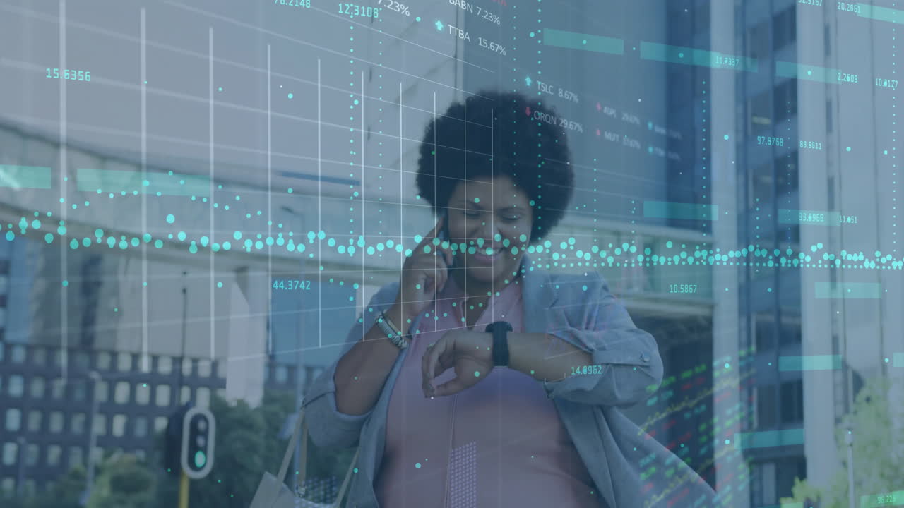 Animation of graphs, trading boards, biracial woman talking on cellphone and looking at smartwatch