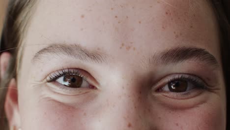 retrato de cerca de los ojos de una adolescente caucásica feliz con pecas sonriendo en cámara lenta