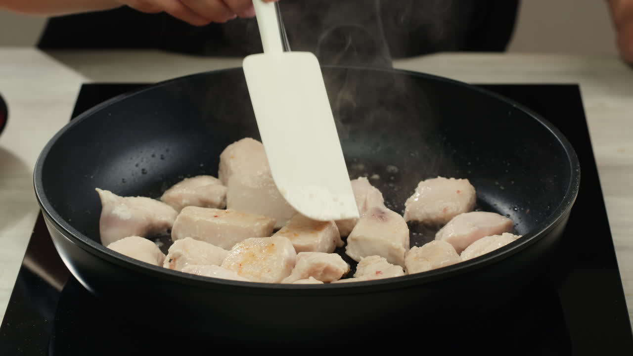 Man slicing raw turkey or chicken meat fillet on oak cutting board closeup, cooking with knife on restaurant kitchen. High quality 4k footage
