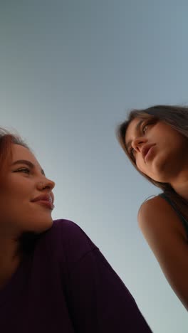 dos mujeres sonriendo hacia el cielo