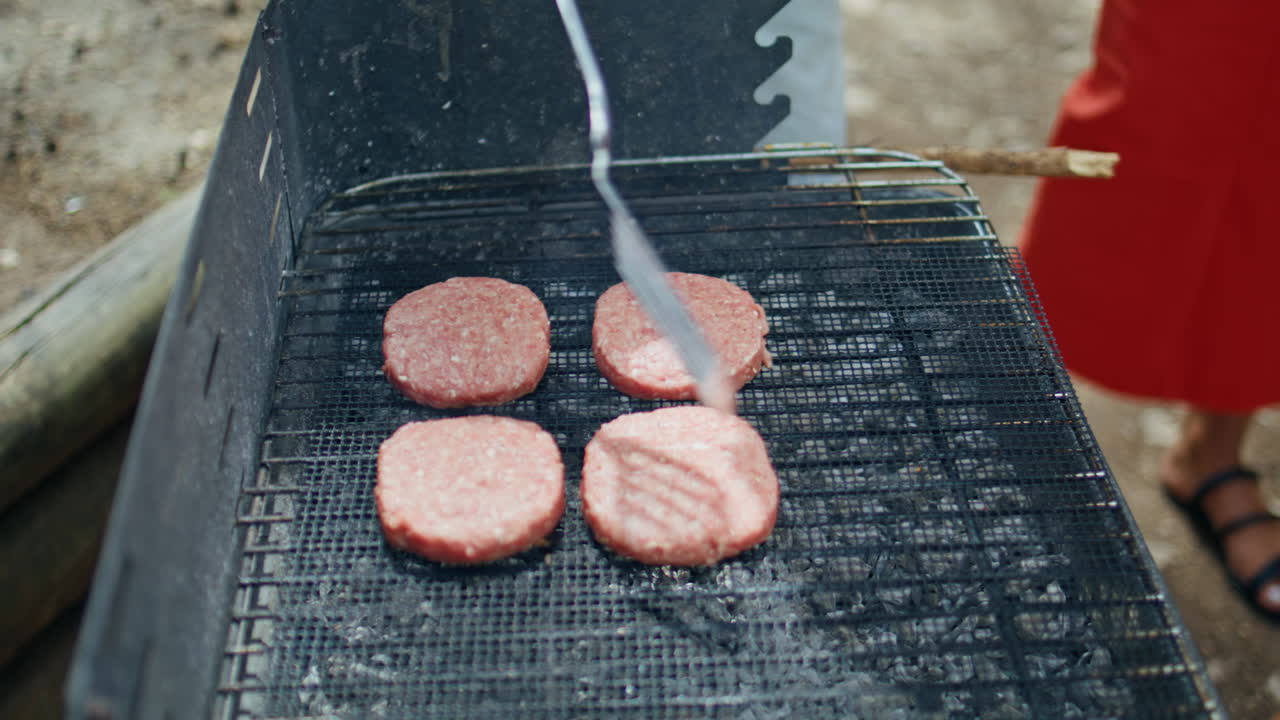 Burger patties grilling barbecue closeup. Unrecognizable man preparing beef