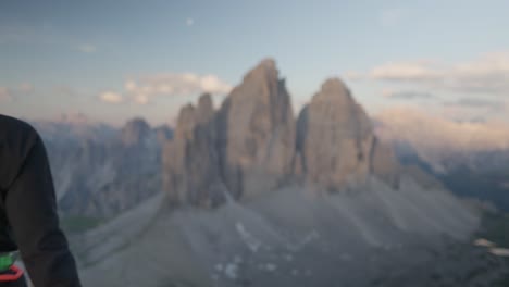 una persona con equipo de escalada caminando frente a los famosos tres picos - tre cime - dolomitas