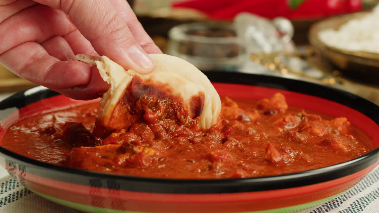 Assorted indian sri-lanka food set on wooden background. Dishes and appetisers of indeed cuisine, rice, lentils, paneer, samosa, spices, masala. Bowls and plates with indian food top view chicken. High quality 4k footage