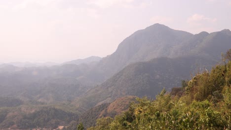 drone shot floating over the saddle of a hike in the mountain town of nong khiaw in laos, southeast asia