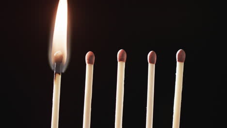 Video of close up of matches with yellow fire flame and copy space on black background