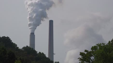 smokestacks belch pollution into the atmosphere releasing greenhouse gas and contributing to global warming