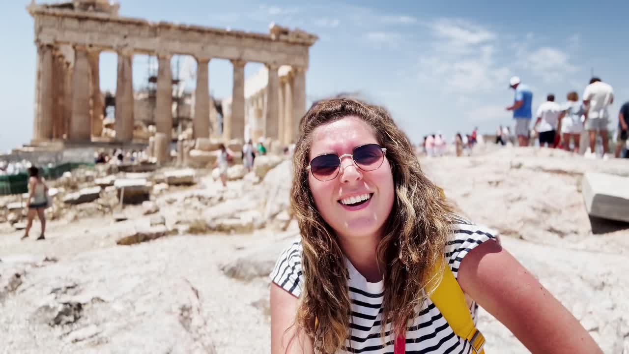Donna che presenta il Partenone alla telecamera, Atene, Grecia