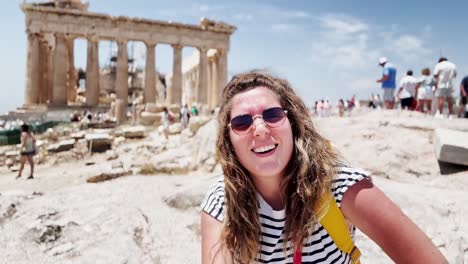 woman presenting the parthenon to the camera, athens, greece