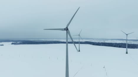 aerial view three wind turbines rotate during the winter and produce green energy for consumers