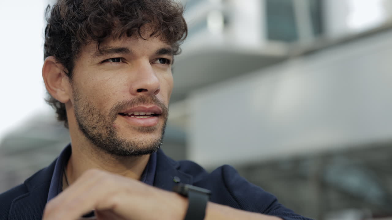 Young Man Talking and Checking Smartwatch Outdoors