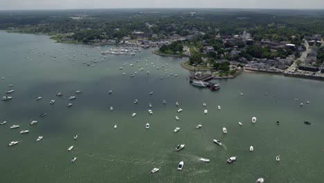 Aerial-view-overlooking-moored-boats-on-the-coast-of-Plymouth,-sunny-USA---tracking,-drone-shot
