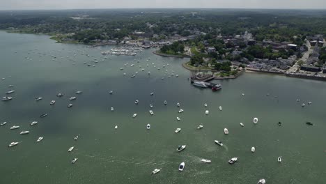 aerial view overlooking moored boats on the coast of plymouth, sunny usa - tracking, drone shot