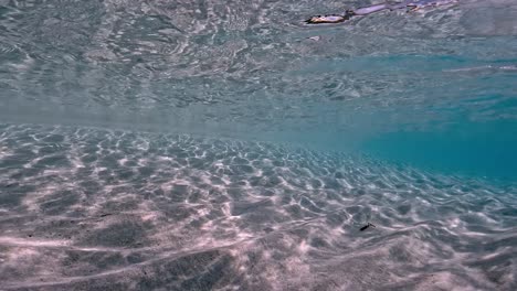 Auténtica-Escena-Submarina-Fpv-De-Agua-De-Mar-Tropical-Turquesa-Cristalina-Con-Superficie-Ondulada-Y-Reflejos-En-El-Fondo-Marino-Con-Fondo-Azul