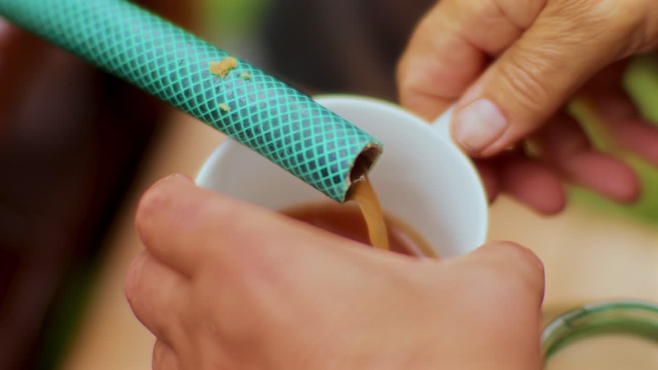 jugo de manzana presionado saliendo de una manguera para llenar algunos vasos