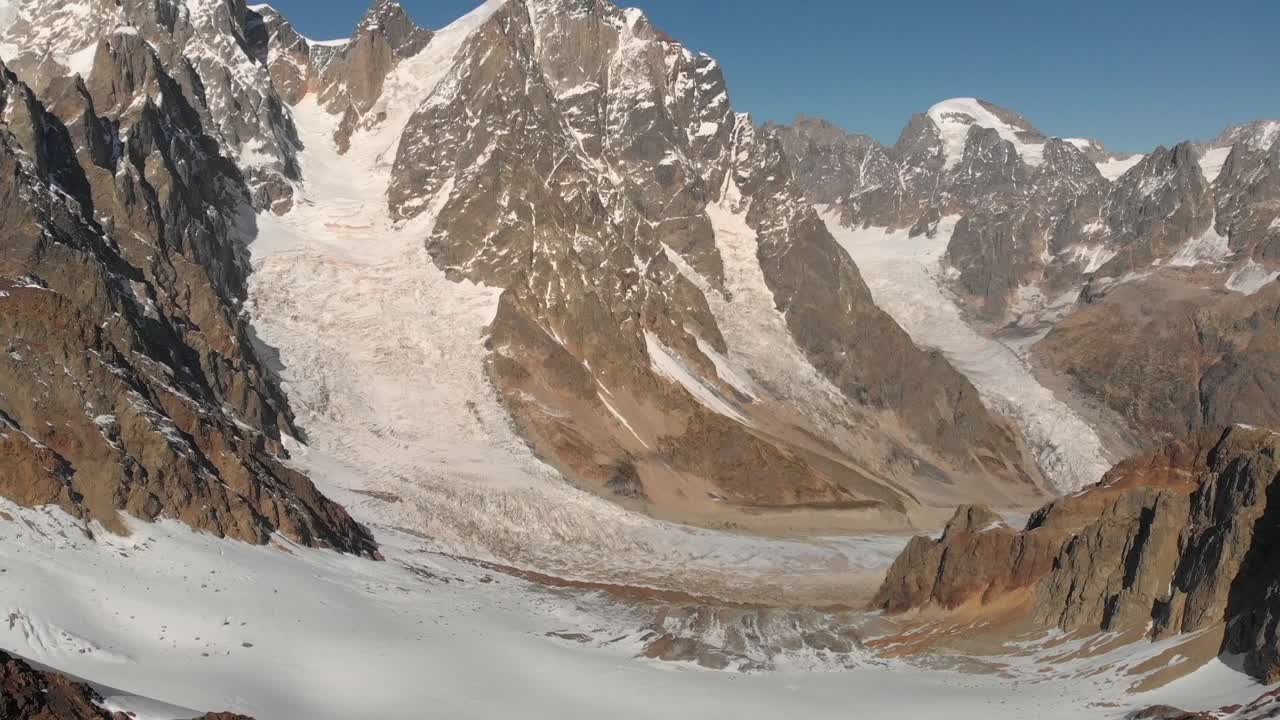 clip aéreo lento del glaciar del monte ushba, en la cima de la montaña, durante un día soleado