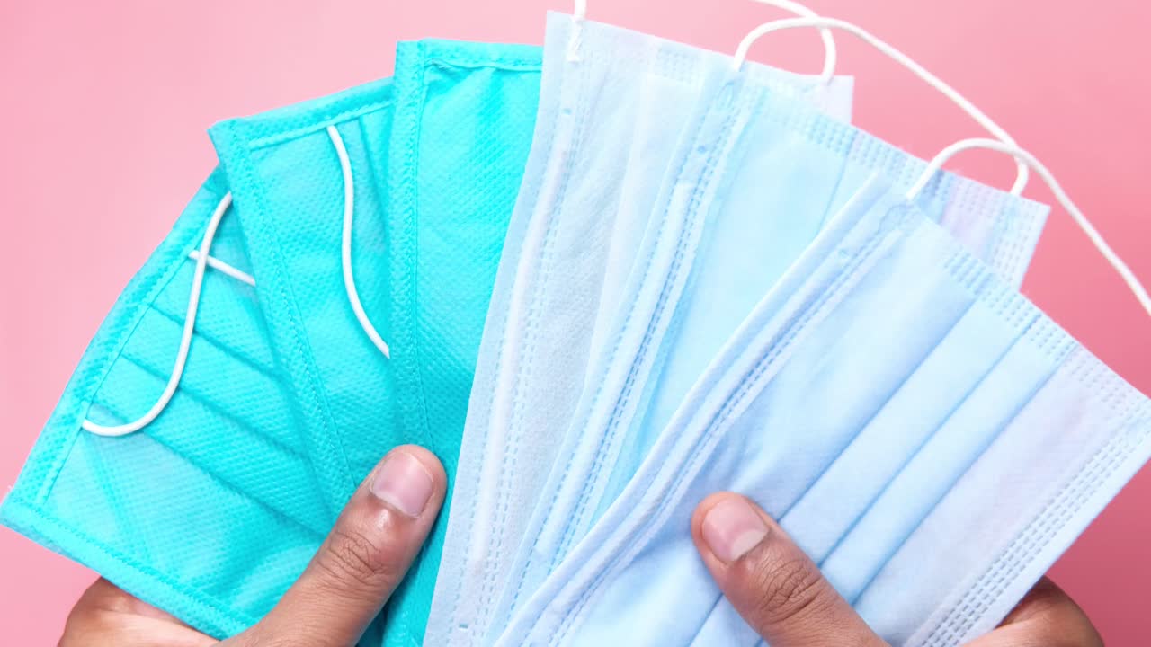 múltiples máscaras faciales en las manos