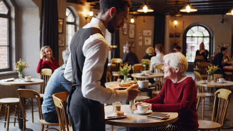 waiter serving food and drink in a cafe