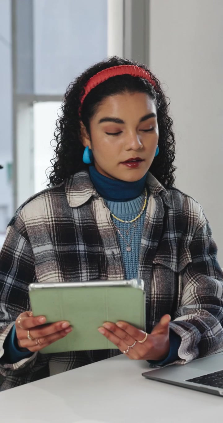 Young Woman Working on Laptop and Tablet in Modern Office