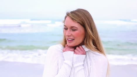 happy blonde smiling at camera on the beach
