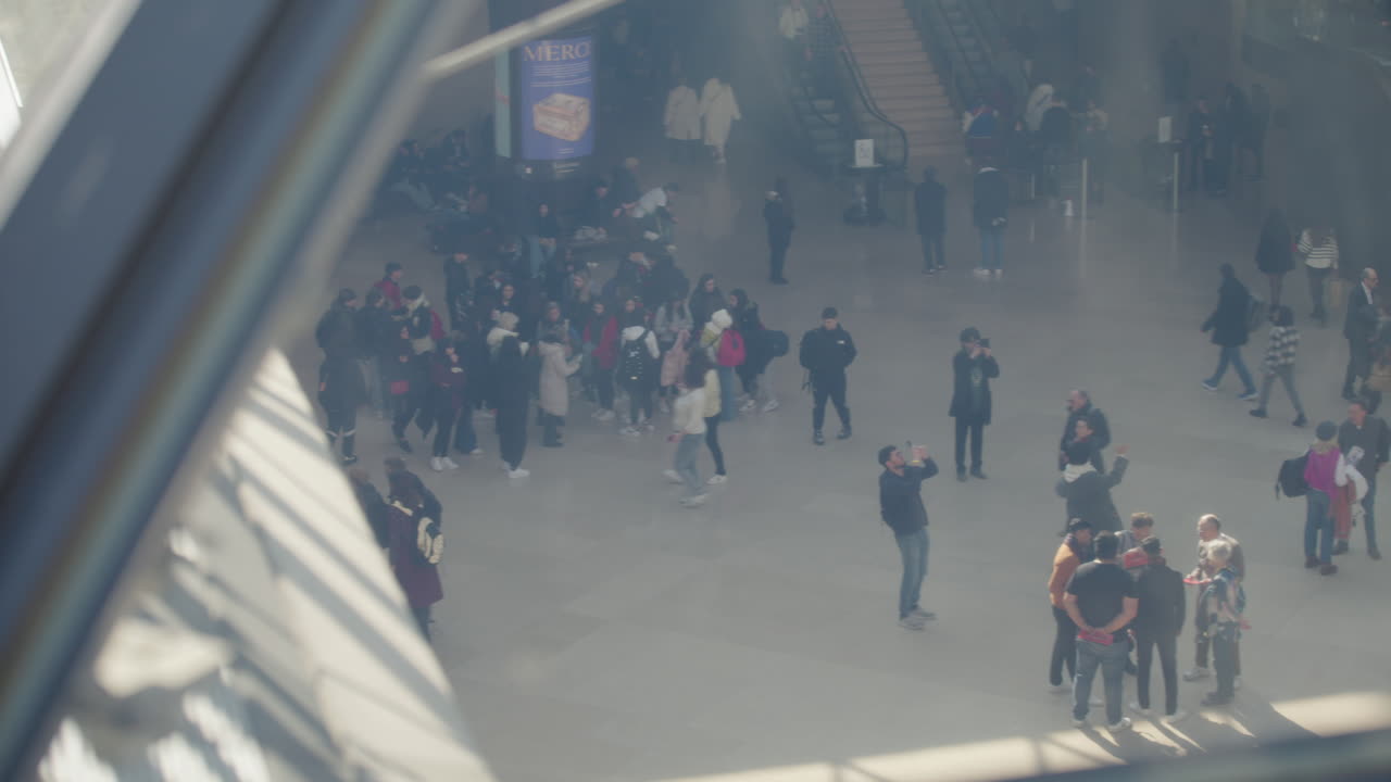 에스컬레이터에서 관광객 무리에게 루브르 유리 피라미드를 내려다보십시오.