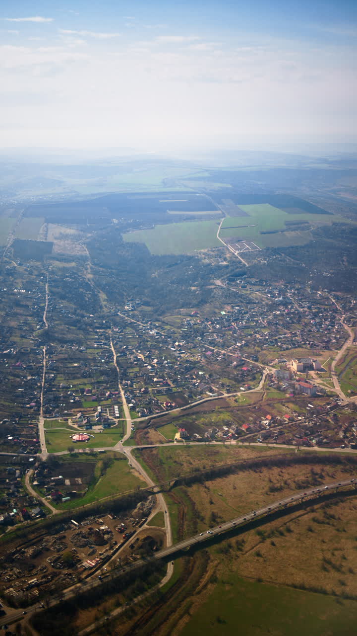 Aerial view of fields and towns from an airplane window. Vertical
