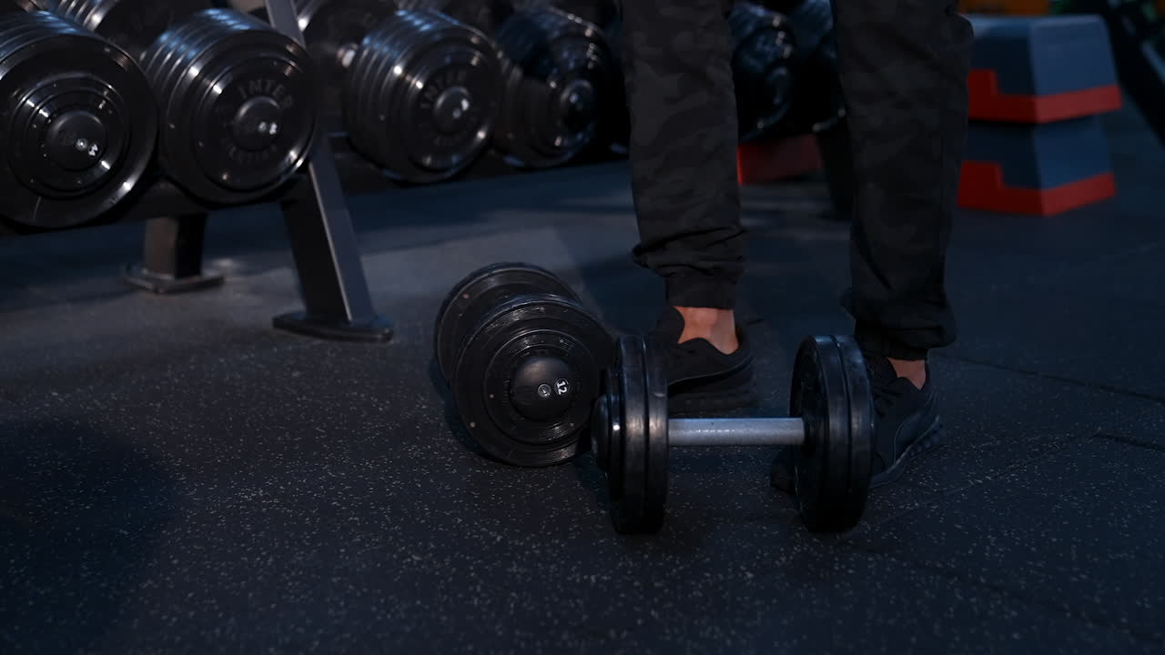 Bodybuilder exercising with dumbbell at gym. Close up of handsome power athletic man bodybuilder doing exercises with dumbbell