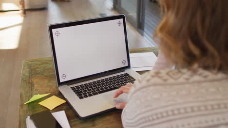 Back-view-of-caucasian-pregnant-woman-working-remotely-using-laptop-with-copy-space