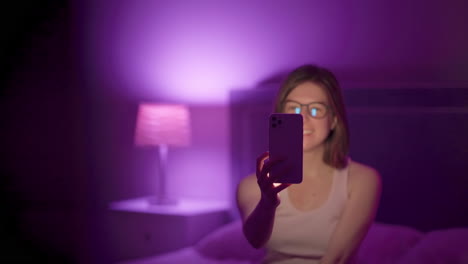 girl fixes hair and takes selfies with flash on late at night