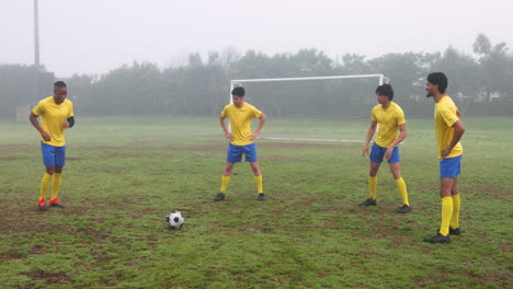 soccer players stretching and warming up on field before match on foggy day