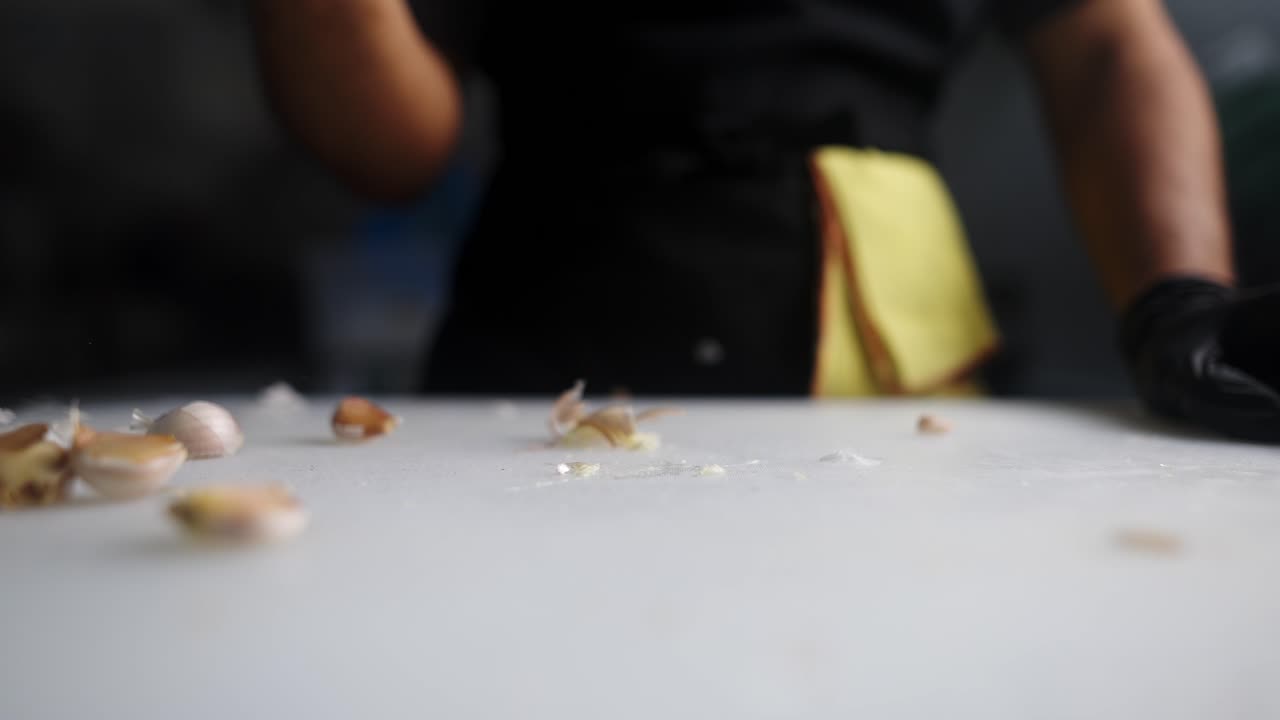 Cinematic creative and stunning view of a chef crushing a garlic bulb in slow motion