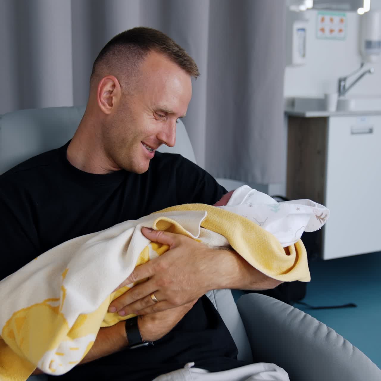 Newborn baby holding on young father hands. Infant small child parenthood concept