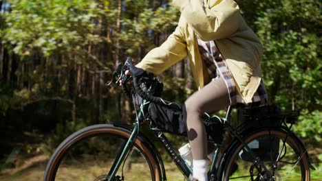 frau fährt an einem sonnigen tag fahrrad in einem wald