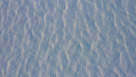 aerial topdown flying backwards over the patterns in the fresh snow