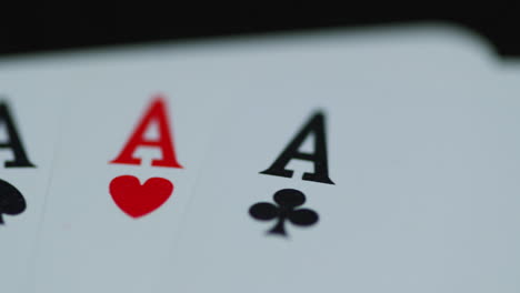 a close up macro shot of playing cards with all four aces hearths diamonds space cross lying on an elephant while moving as the cards slowly expose from the side