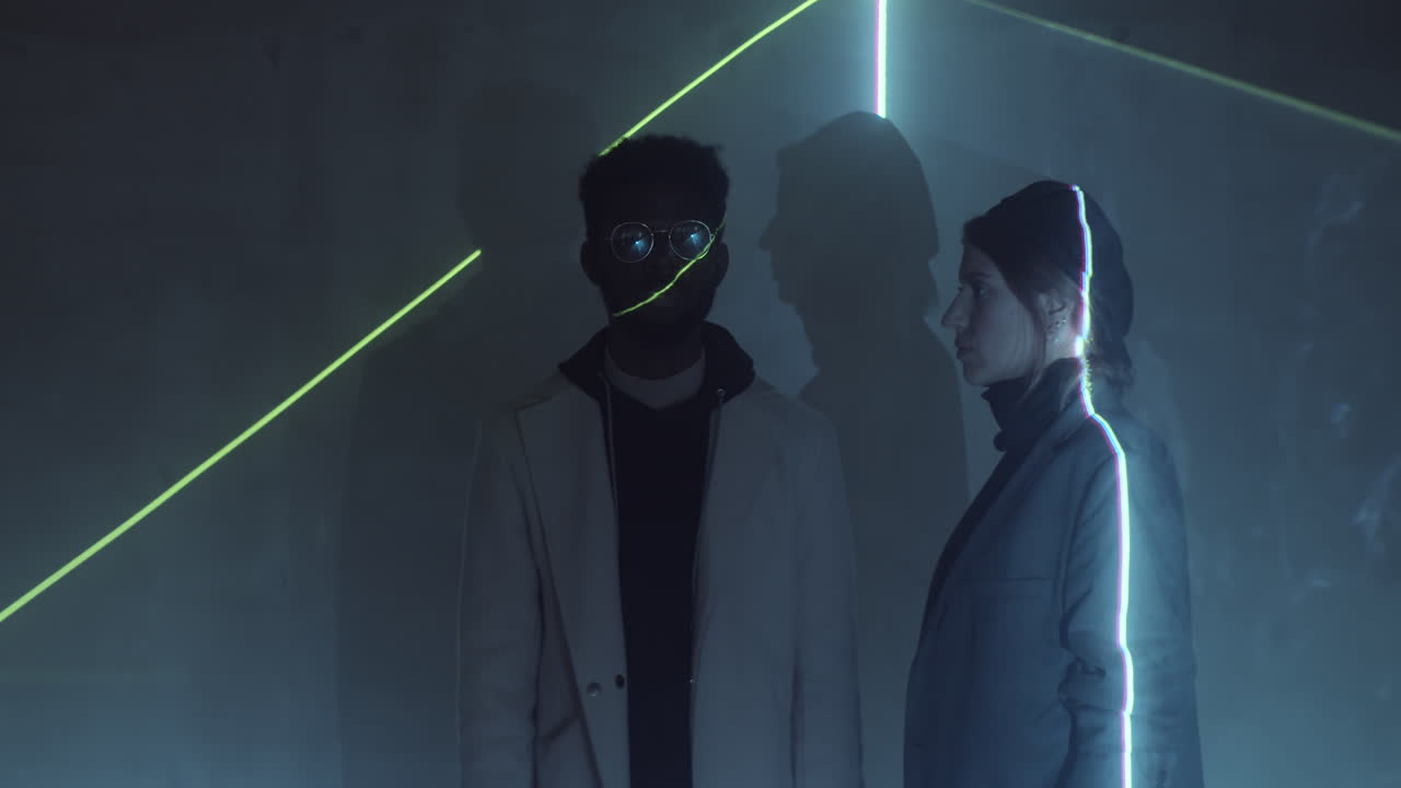 레이저 선을 움직이는 어두운 방에 있는 다양한 커플