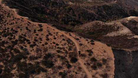 un hombre montando la montaña en bicicleta con traje negro
